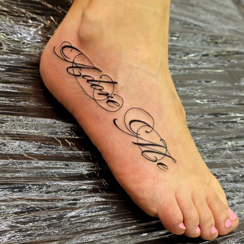 Flowing calligraphic script lettering across the top of a foot