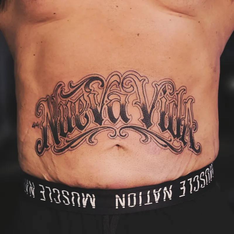 Ornate Chicano script reading "Nueva Vida" with filigree flourishes across a stomach
